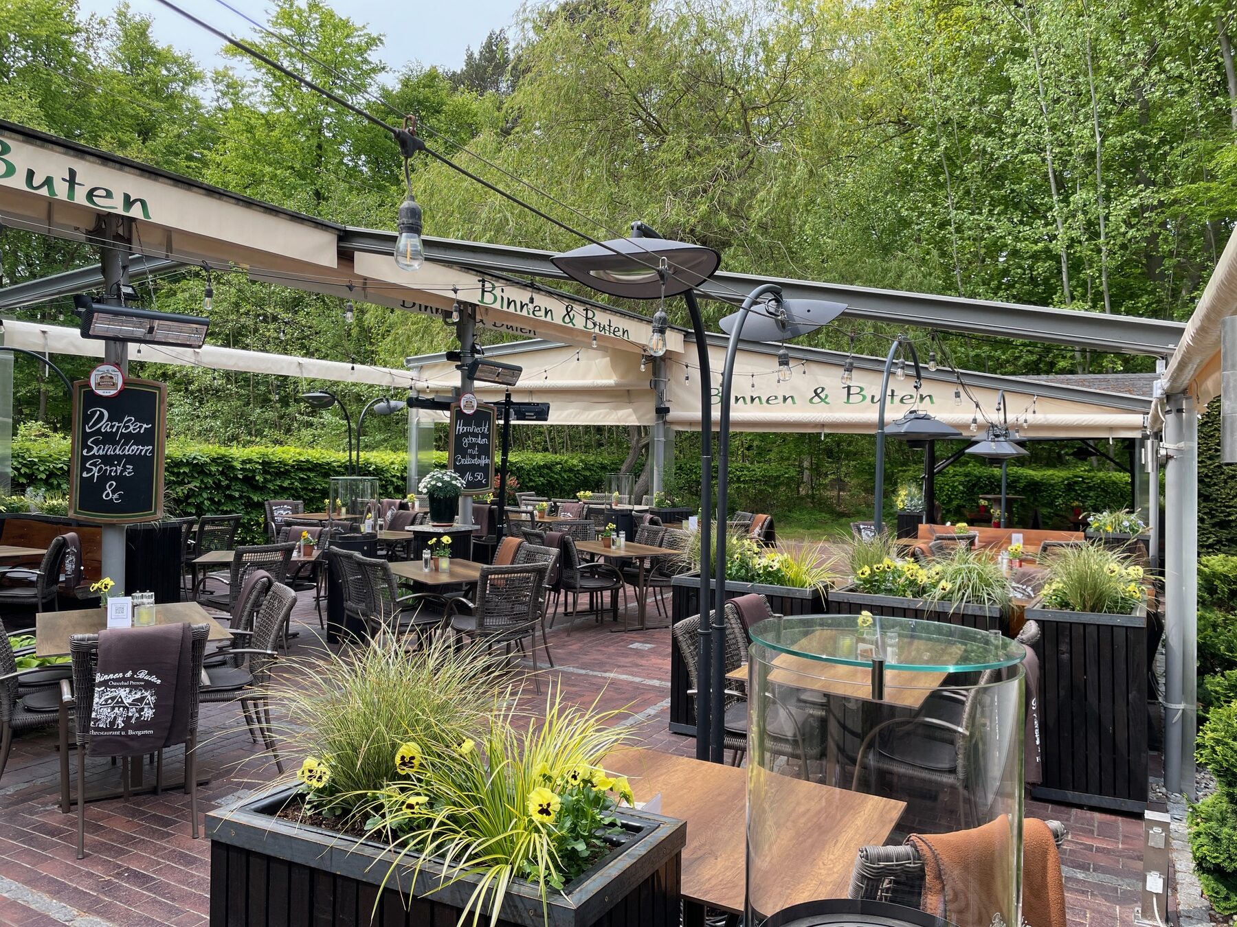 Weiter Blick über die Terrasse mit Lichterketten und Blumenkübeln